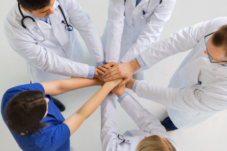Photodune 20801960 Group Of Doctors With Hands Together At Hospital Xxl 1 768x512 